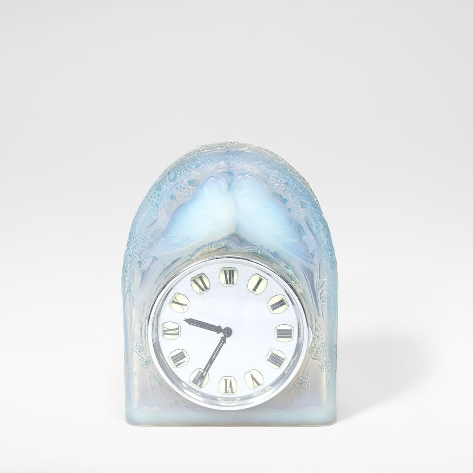 René Lalique 'Deux Colombes' clock, model no. 727, designed 1926: René Lalique 'Deux Colombes' clock, model no. 727, designed 1926 Opalescent glass, frosted and polished, with remnants of blue staining. 27.5 cm high, 22.5 cm wide, 10 cm deep Side moulded