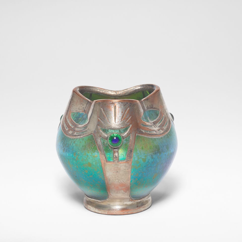 Loetz 'Papillon' vase, circa 1900: Loetz 'Papillon' vase, circa 1900 Blown glass with speckled iridescence, of globular form with a pinched trefoil rim, with stylised silvered copper mounts decorated with cabochons. 8.5 cm high, 8 cm