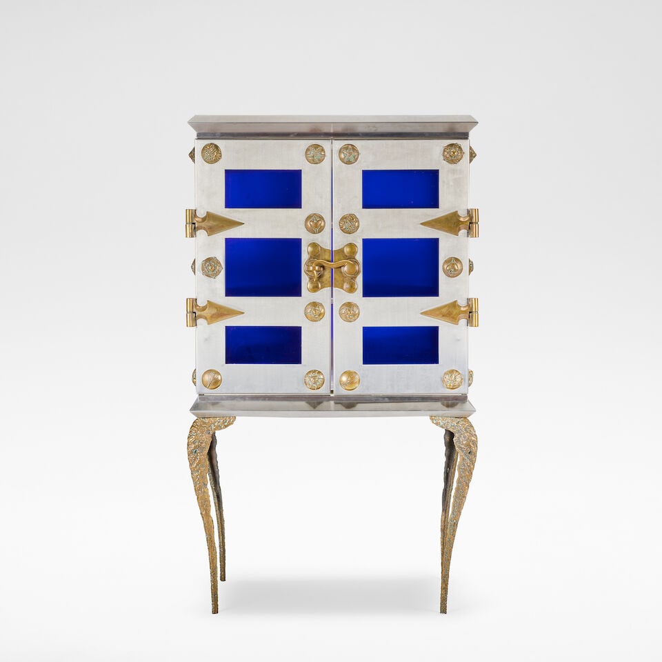 Mark Brazier-Jones 'Mount' cabinet, 1994: Mark Brazier-Jones 'Mount' cabinet, 1994 Stainless steel, bronze and cobalt glass, the pair of doors opening onto three glass shelves. 173 cm high, 99 cm wide, 69 cm deep Signed, numbered and dated