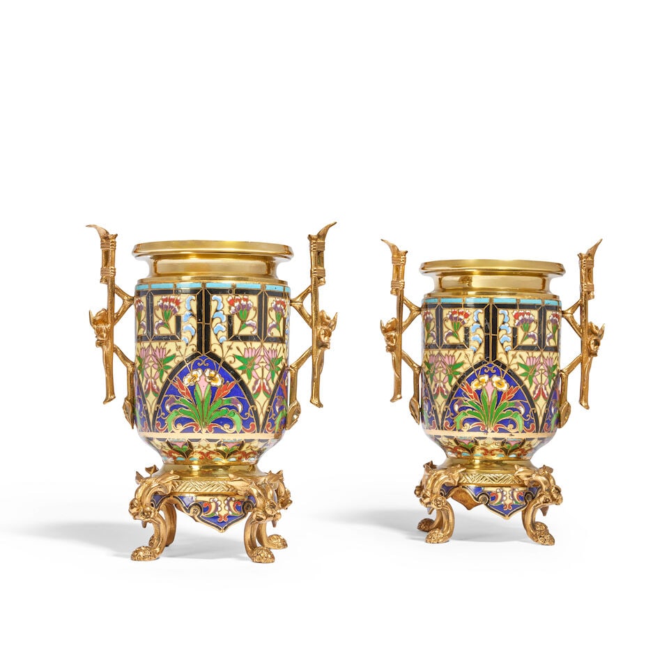 A pair of French brass and gilt metal mounted twin-handled gilt bronze and champlevé garnit...: A pair of French brass and gilt metal mounted twin-handled gilt bronze and champlevé garniture urns In the manner of Maison Alphonse Giroux Of cylindrical form, their bodies with elaborate floral