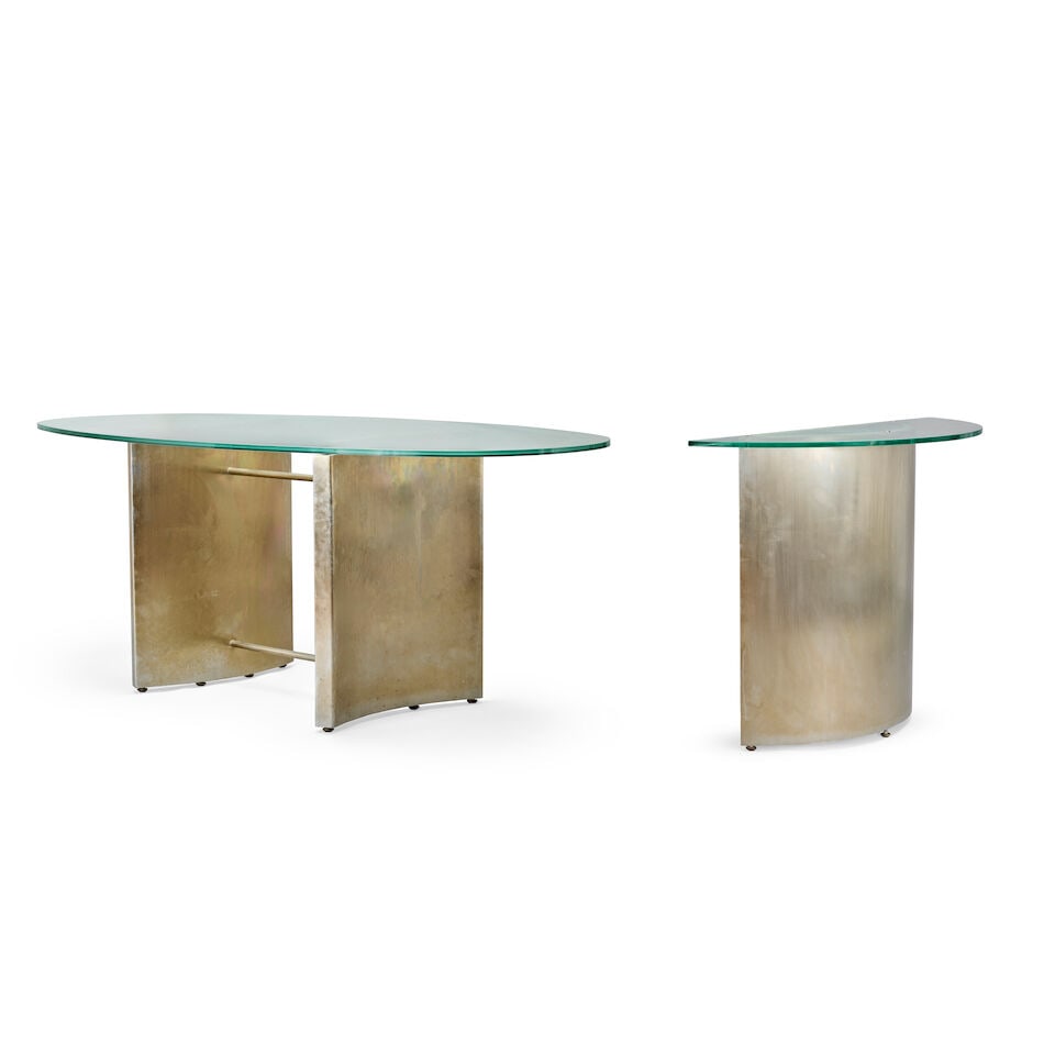 A steel and glass dining table designed by Nicky Haslam together with a matching console table (2): A steel and glass dining table designed by Nicky Haslam together with a matching console table The dining table with an oval glass top with a frosted inner oval medallion, on two opposing steel convex