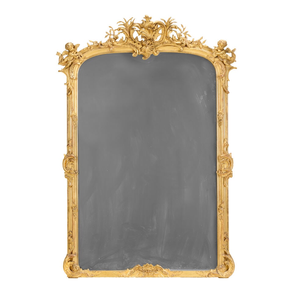 A mid or third quarter 19th century Rococo revival giltwood and gilt composition 1850-1870: A mid or third quarter 19th century Rococo revival giltwood and gilt composition 1850-1870 The arched plate within a moulded frame with scrolled foliate, floral and rocaille carved adornments, surmoun