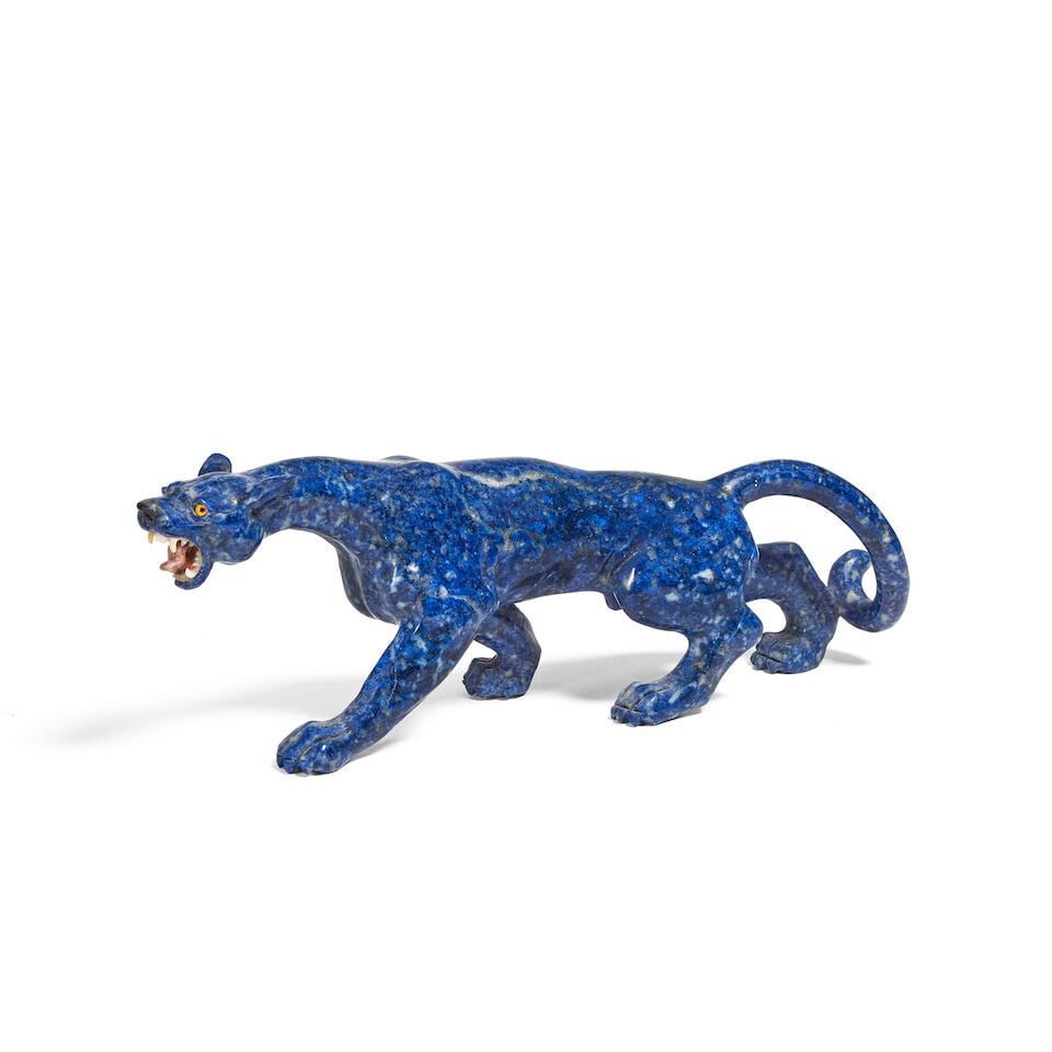 A carved lapis lazuli model of a panther probably Idar-Oberstein, Germany, in the manner of mod...: A carved lapis lazuli model of a panther probably Idar-Oberstein, Germany, in the manner of models sold by Aspreys of London The stalking beast snarling with opalescent teeth and inset yellow glass ey