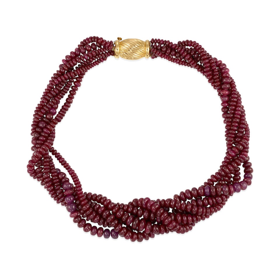 18K GOLD AND RUBY TORSADE NECKLACE: 18K GOLD AND RUBY TORSADE NECKLACE • 18k yellow gold • 6 graduated strands of numerous round ruby beads measuring from 4.50 mm to 8.00 mm each in diameter • Length 16 in •