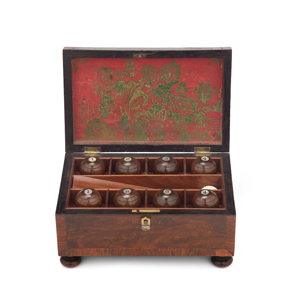 A Regency mahogany and rosewood crossbanded indoor boules set Early 19th century: A Regency mahogany and rosewood crossbanded indoor boules set Early 19th century The hinged lid enclosing eight mother-of-pearl numbered boules with a white polished resin jack, 24cm wide, 15.5cm deep