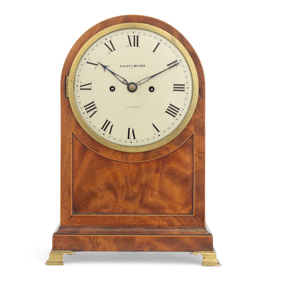 A Regency mahogany bracket clock Haley & Milner of London: A Regency mahogany bracket clock Haley & Milner of London The arched case with pierced frets to sides, raised on brass ogee bracket feet, the 7 inch dial with Roman numerals and signed 'Haley & Milner