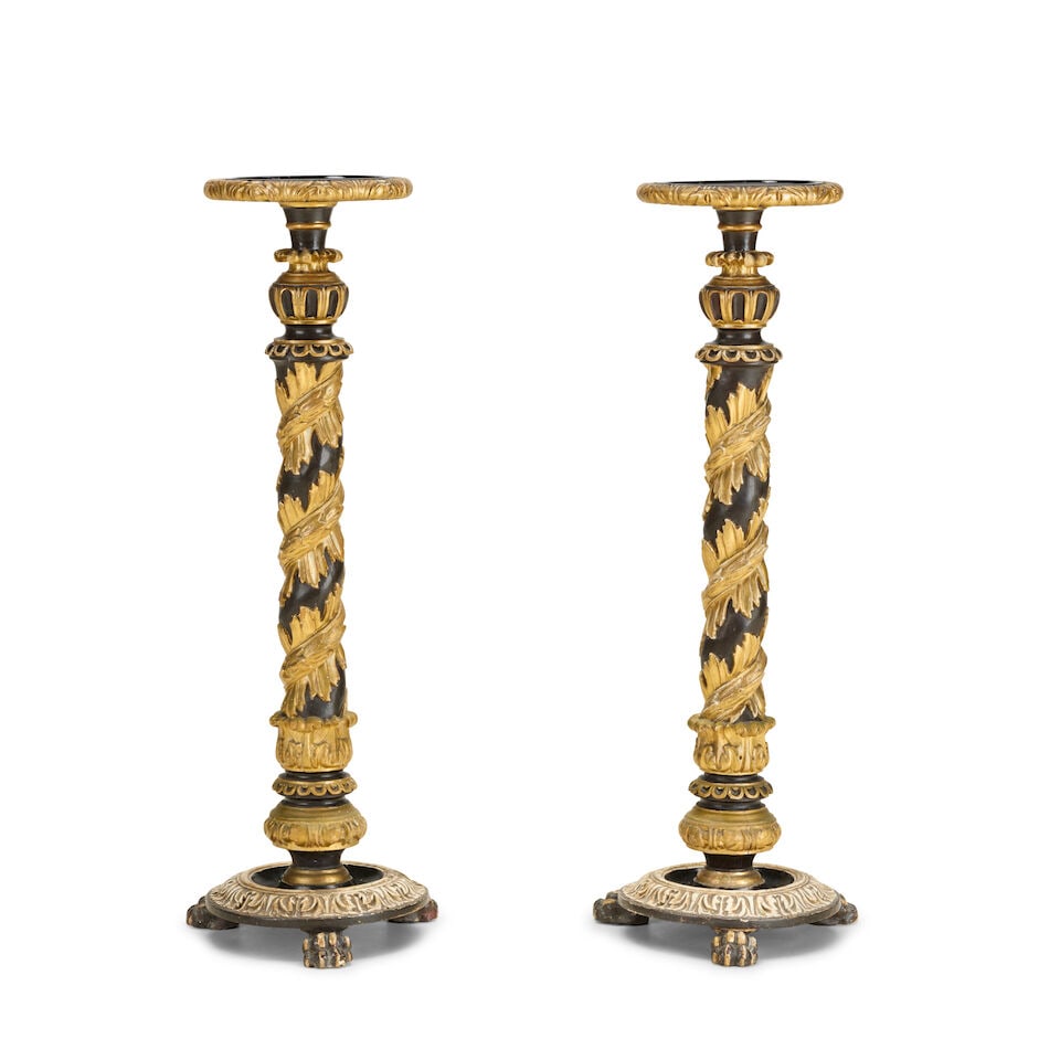 A pair of Italian ebonised and carved giltwood and gesso torchères Late 19th century (2): A pair of Italian ebonised and carved giltwood and gesso torchères Late 19th century The circular dished tops above foliate decorated spiral turned columns on acanthus leaf decorated circular pli