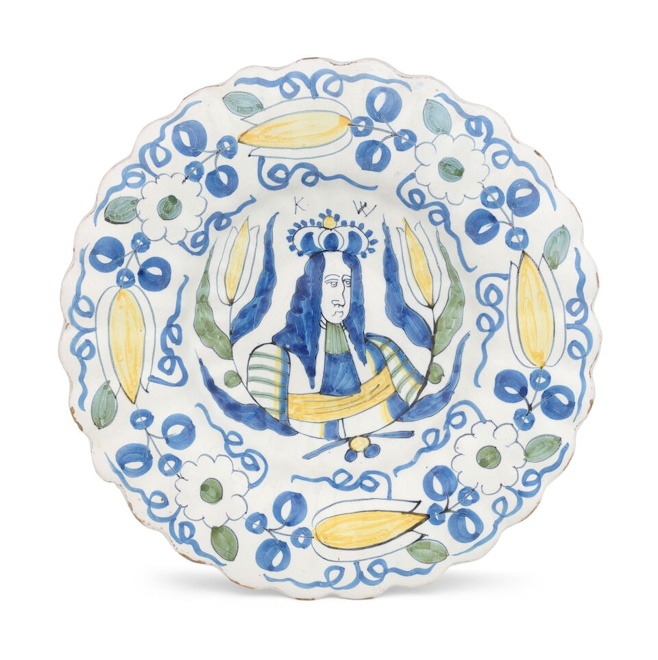 A Dutch Delft Royal portrait charger, late 17th century: A Dutch Delft Royal portrait charger, late 17th century The dish moulded with rows of flutes, painted in blue, yellow and green with a central portrait of King William III, titled 'K W', within a half