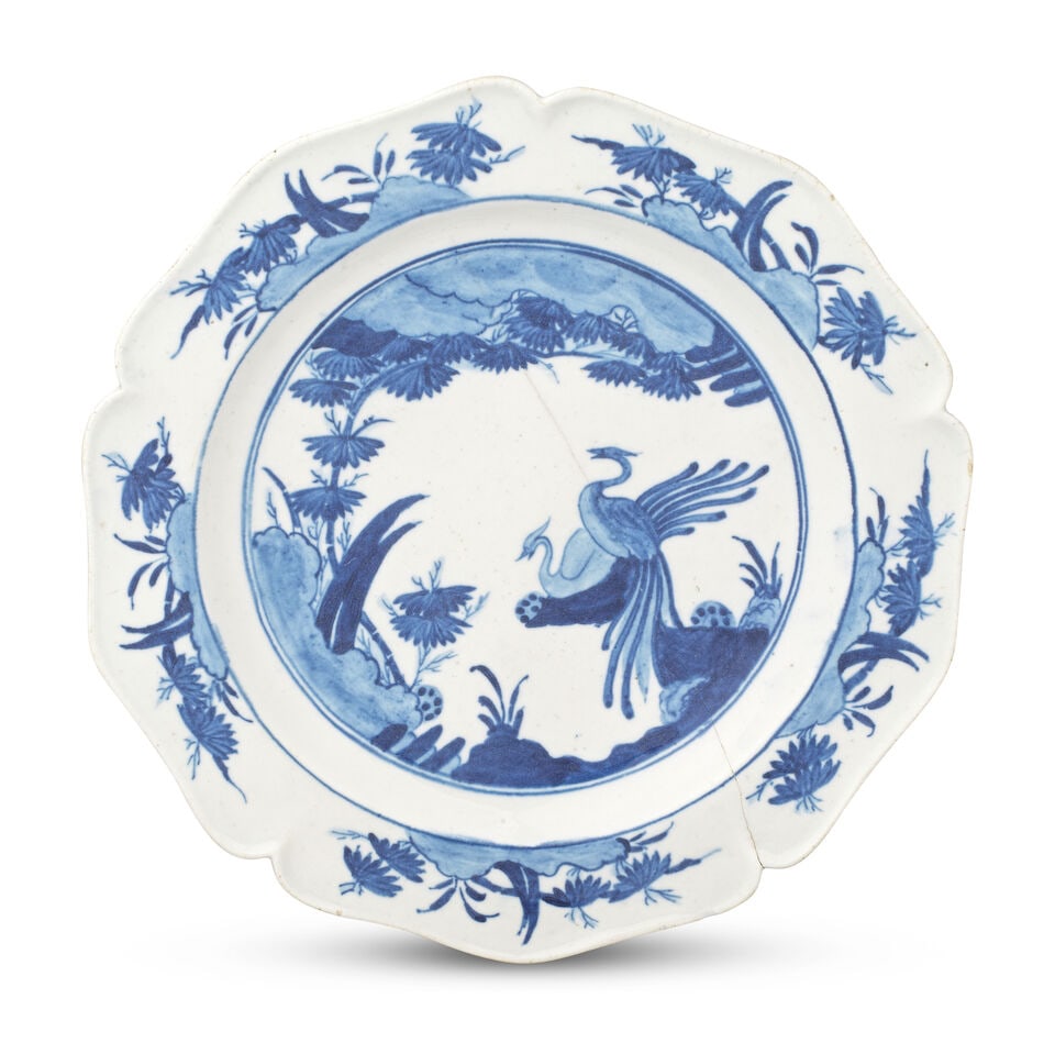An exceptionally rare Chelsea blue and white plate, circa 1755: An exceptionally rare Chelsea blue and white plate, circa 1755 With a petal-lobed rim, painted in underglaze blue with two long-tailed birds perched on an outcrop, vegetation issuing from a rocky land