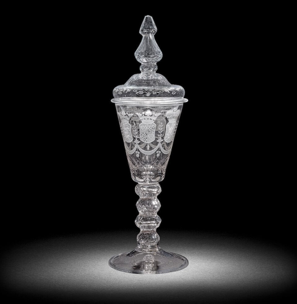 A Dutch engraved armorial goblet and a cover, second quarter 18th century: A Dutch engraved armorial goblet and a cover, second quarter 18th century The glass German, the funnel bowl with a solid base containing a small tear and cut with a band of petal-like facets to the lo