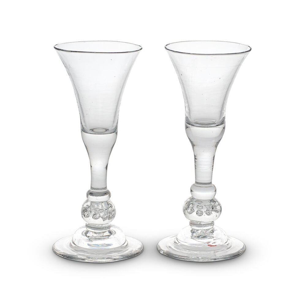 A near pair of unusual composite stem wine glasses, circa 1730-40: A near pair of unusual composite stem wine glasses, circa 1730-40 The waisted bell bowls with solid bases extending into plain stems terminating in flattened knops, above generous cushioned beaded bas
