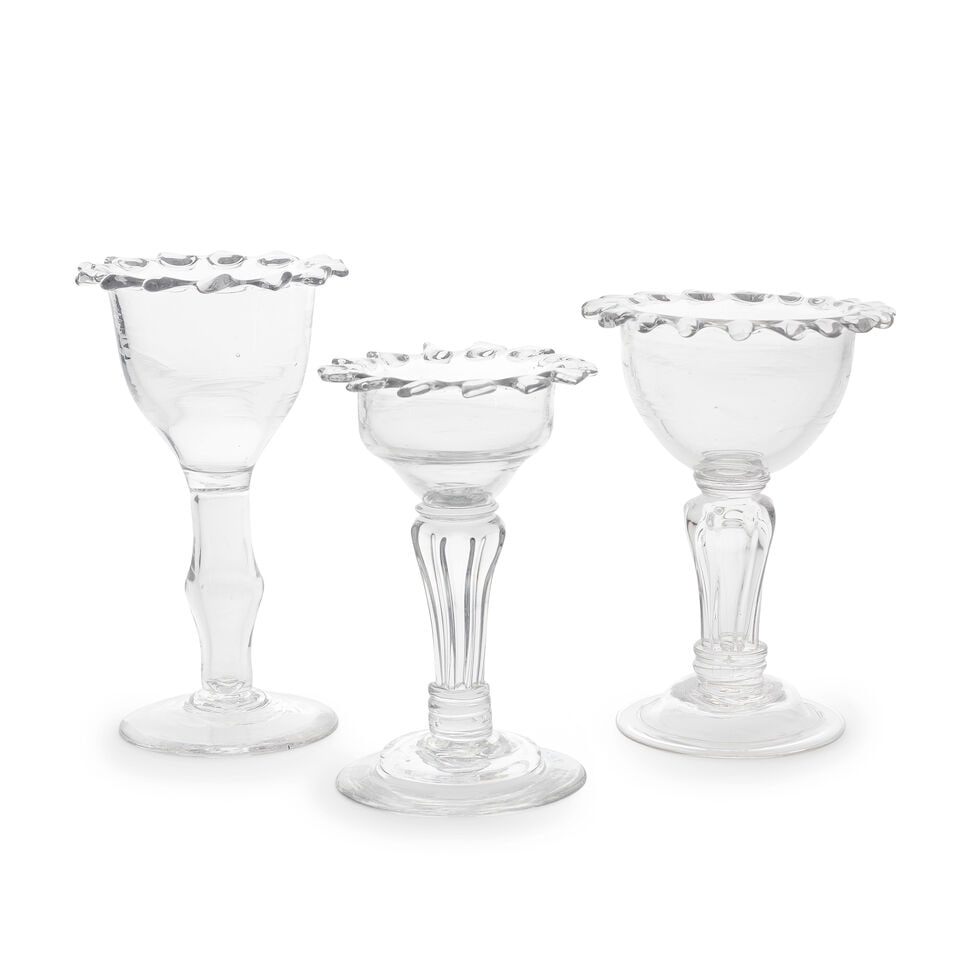 Two rare moulded stem sweetmeat glasses and a hollow-stem 'excise' sweetmeat glass, circa 1740-50: Two rare moulded stem sweetmeat glasses and a hollow-stem 'excise' sweetmeat glass, circa 1740-50 With distinctive pincered or dentated rims, two with eight-sided pedestal stems terminating in basal c