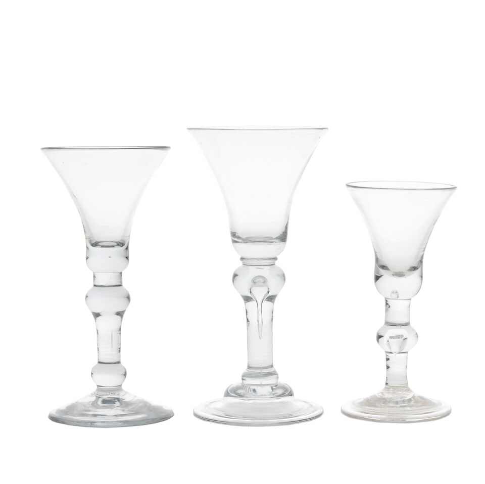 Three good baluster wine glasses, circa 1720-30: Three good baluster wine glasses, circa 1720-30 With waisted bell bowls solid at the bases, one set on a collar above a teared inverted baluster with a basal knop, over a domed folded foot, 18.5cm hig