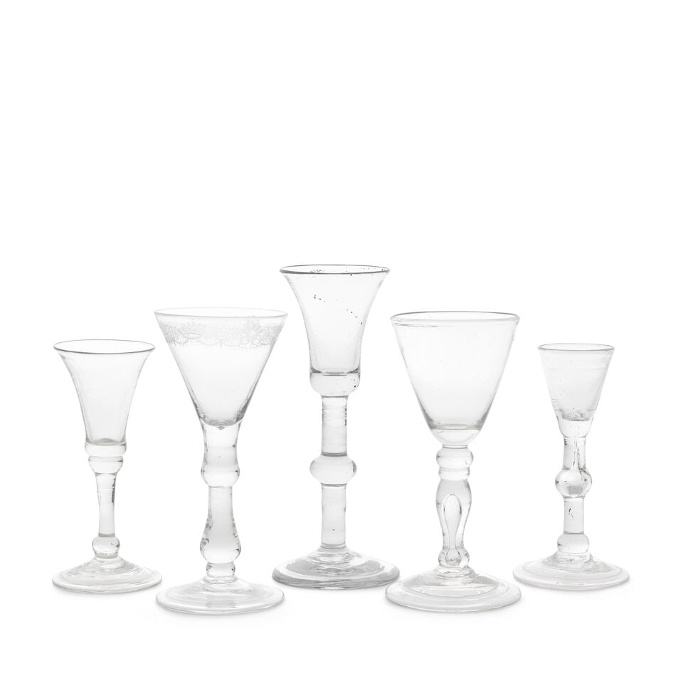 Three baluster wine glasses and two gin glasses, circa 1730-50: Three baluster wine glasses and two gin glasses, circa 1730-50 One with a conical bowl engraved with a formal scrollwork border, on a solid double drop-knopped stem terminating in a small basal knop,