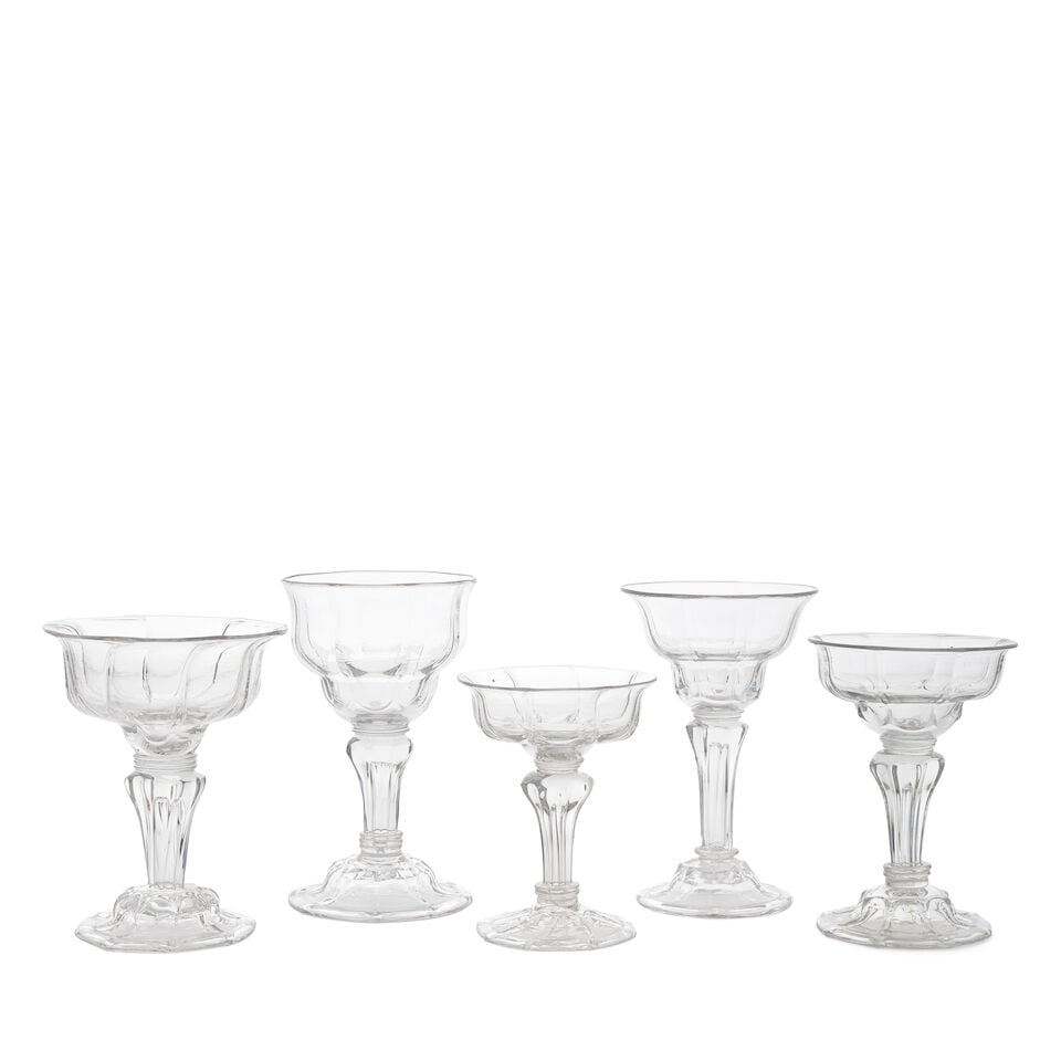 Five moulded stem sweetmeat or champagne glasses, circa 1740-50: Five moulded stem sweetmeat or champagne glasses, circa 1740-50 The panel-moulded lipped double ogee bowls set on collars, above on eight-sided pedestal stems containing elongated tears, comprising fo