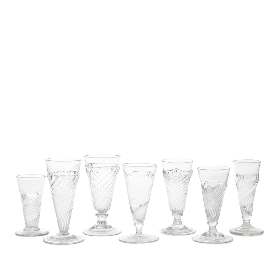 Seven interesting short or 'dwarf' ale glasses, 18th century: Seven interesting short or 'dwarf' ale glasses, 18th century With wrythen moulding, comprising five with flamiform fringes, including one with a conical bowl set without a stem onto a folded conical f
