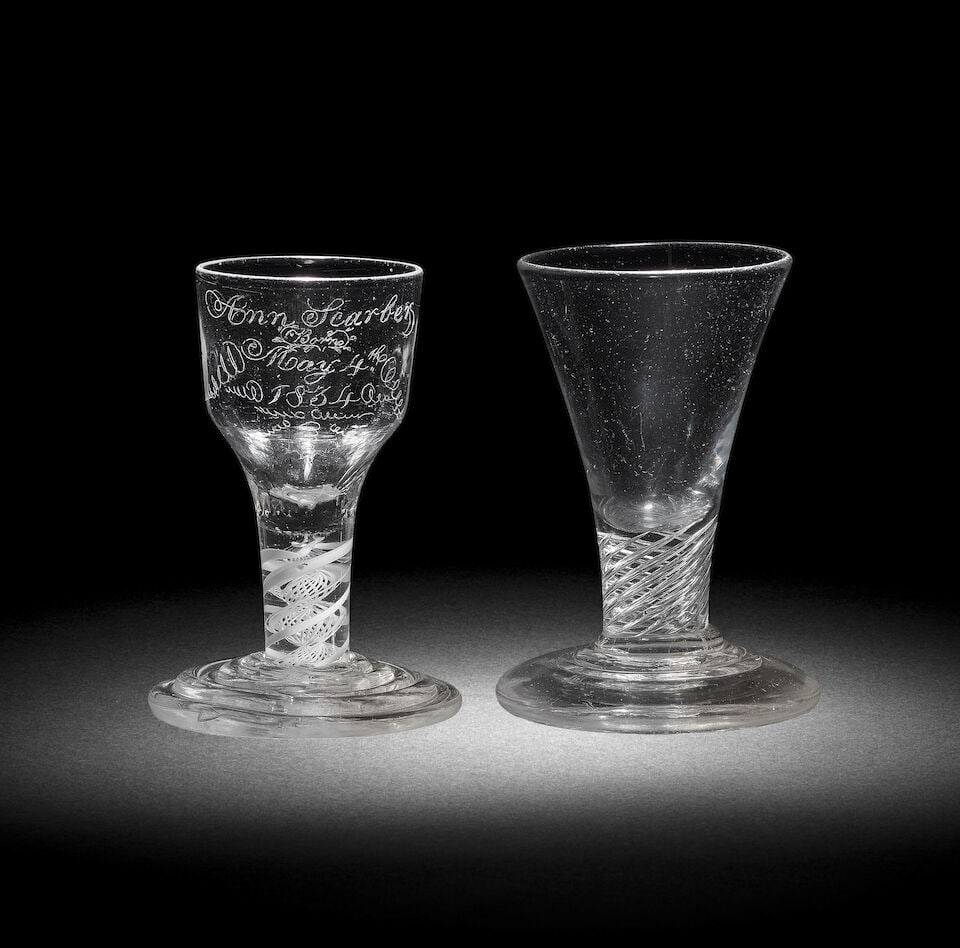 An interesting engraved opaque twist firing glass and an airtwist firing glass, circa 1750-65: An interesting engraved opaque twist firing glass and an airtwist firing glass, circa 1750-65 With heavy terraced 'firing' feet, the first with an ogee bowl moulded fine basal flutes, later inscribed