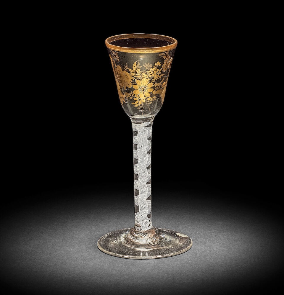 A Giles gilded opaque twist wine glass, circa 1765: A Giles gilded opaque twist wine glass, circa 1765 Decorated in the London workshop of James Giles, the round funnel bowl decorated with a spray of flowers and scattered floral sprigs beneath a gilt r