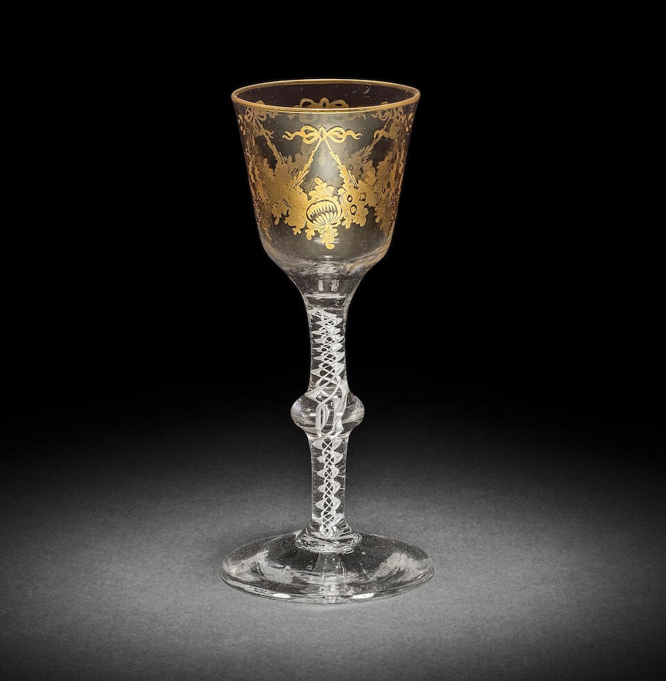 A fine gilded opaque twist wine glass, circa 1765: A fine gilded opaque twist wine glass, circa 1765 Perhaps decorated in the London workshop of James Giles, the generous ogee bowl decorated with six overlapping garlands of stylised flowers pendant fr