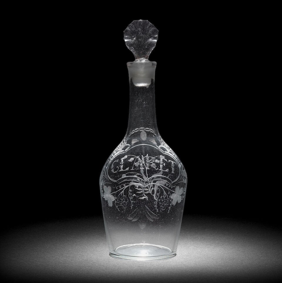 A fine engraved Claret decanter and stopper, circa 1765: A fine engraved Claret decanter and stopper, circa 1765 Of shouldered form, decorated on one side with a shaped cartouche hung from a chain around the neck and issuing sprays of fruiting vine, inscrib