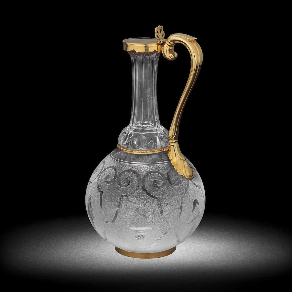 A silver-gilt mounted cut and etched glass claret jug, dated 1865: A silver-gilt mounted cut and etched glass claret jug, dated 1865 The globular body etched with a gothic design, the hexagonal faceted neck with a facet-cut collar at the base, mounted in silver-gilt