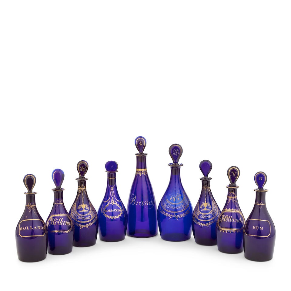 Nine gilded blue glass decanters and stoppers, first quarter 19th century: Nine gilded blue glass decanters and stoppers, first quarter 19th century In deep cobalt-blue glass, all but one with lozenge stoppers, eight of 'club' shape to include two matching pairs, gilded with