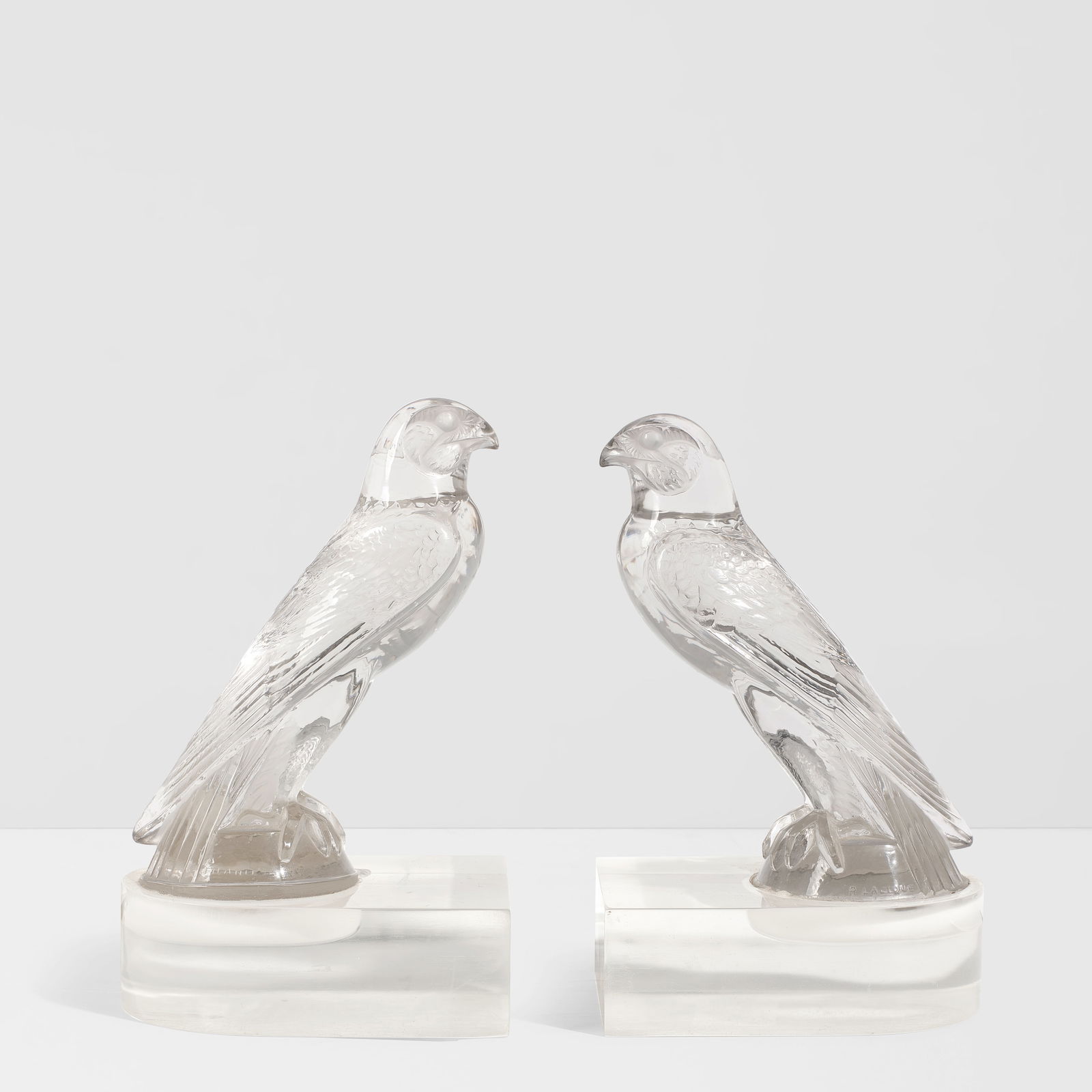 RENÉ LALIQUE (ESTABLISHED 1888) Pair of Faucon Mounted as BookendsMarcilhac 1124, designed ...: RENÉ LALIQUE (ESTABLISHED 1888) Pair of Faucon Mounted as Bookends Marcilhac 1124, designed 1925 molded glass with acrylic base, both with molded signature 'R. LALIQUE' and etched 'FRANCE' height