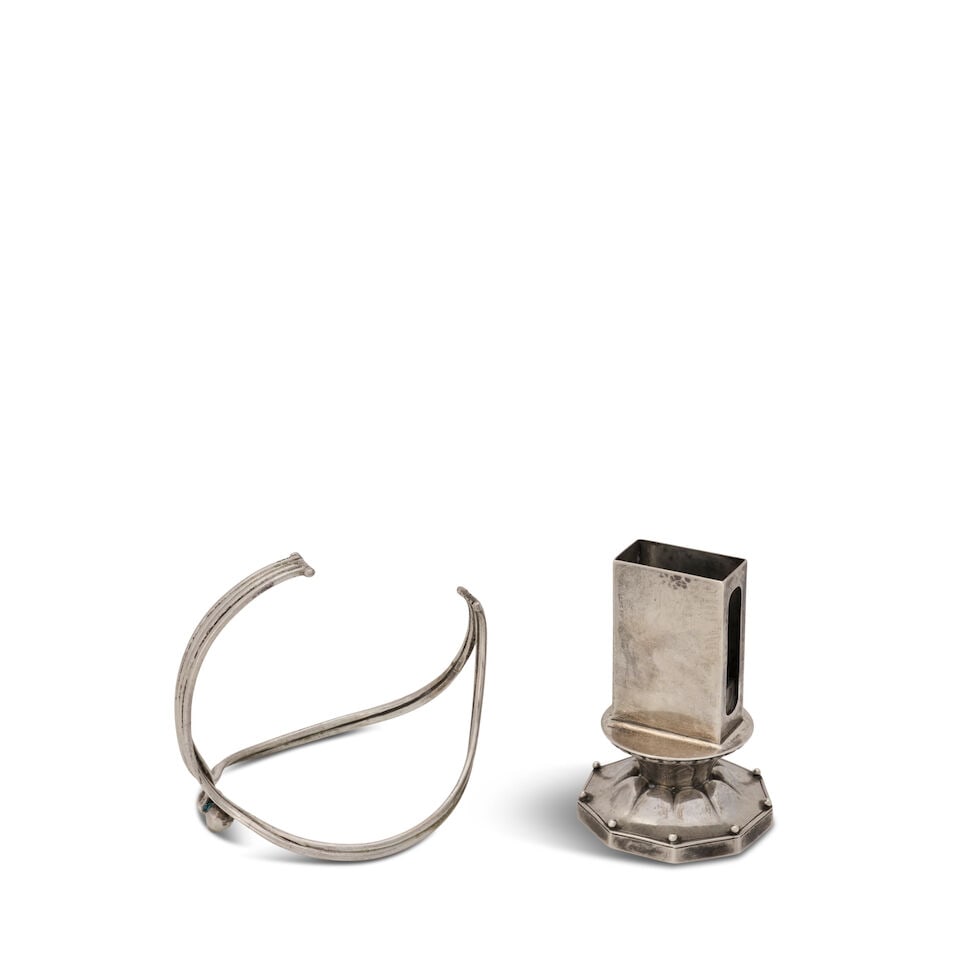 TWO GEORG JENSEN TABLE ITEMS Denmark, sterling silver, matchbox holder, 1925-1932, impressed sta...: TWO GEORG JENSEN TABLE ITEMS Denmark, sterling silver, matchbox holder, 1925-1932, impressed stamp maker's mark and 'Sterling, 461,' ht. 3 5/8, wine bottle holder, designed by Harald Nielsen, 1933-194