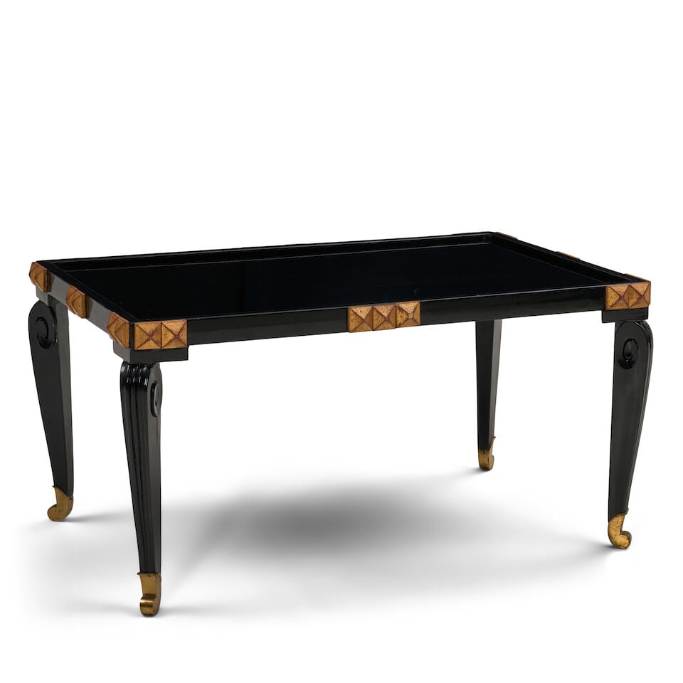 FRENCH MODERNE COFFEE TABLE IN THE MANNER OF MAISON DOMINIQUE France, circa 1950, parcel-gilt, c...: FRENCH MODERNE COFFEE TABLE IN THE MANNER OF MAISON DOMINIQUE France, circa 1950, parcel-gilt, carved and lacquered wood, glass, gilt metal sabots, unmarked, ht. 20 1/2, wd. 40 1/4, dp. 25 3/4 in. For