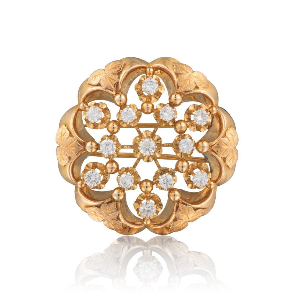 BOUCHERON: BROCHE DIAMANTS: BOUCHERON: BROCHE DIAMANTS Formant une rosace ajourée, ponctuée de diamants de taille brillant, la monture en or jaune ornée de feuilles de vigne, signée Boucheron Paris, poinç