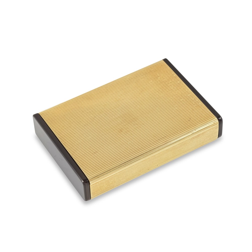 CARTIER: BOÎTE OR ET ONYX: CARTIER: BOÎTE OR ET ONYX De forme rectangulaire, la monture en or jaune strié, deux côtés ornés de plaques d'onyx, signée CARTIER-PARIS, numérotée, poinço