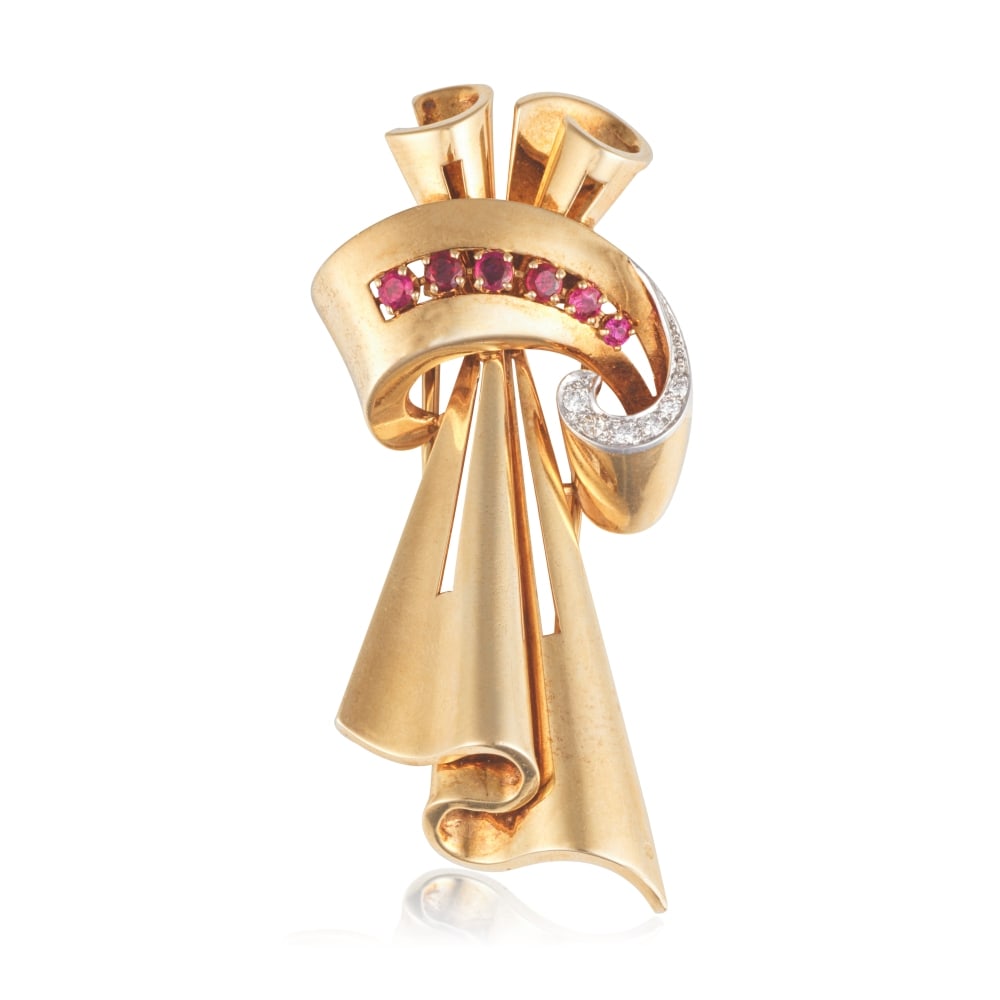 CARTIER: BROCHE RUBIS ET DIAMANTS: CARTIER: BROCHE RUBIS ET DIAMANTS Formant un noeud stylisé en or jaune, réhaussée de rubis de forme ronde et de diamants de taille brillant, signée CARTIER, numérotée, po