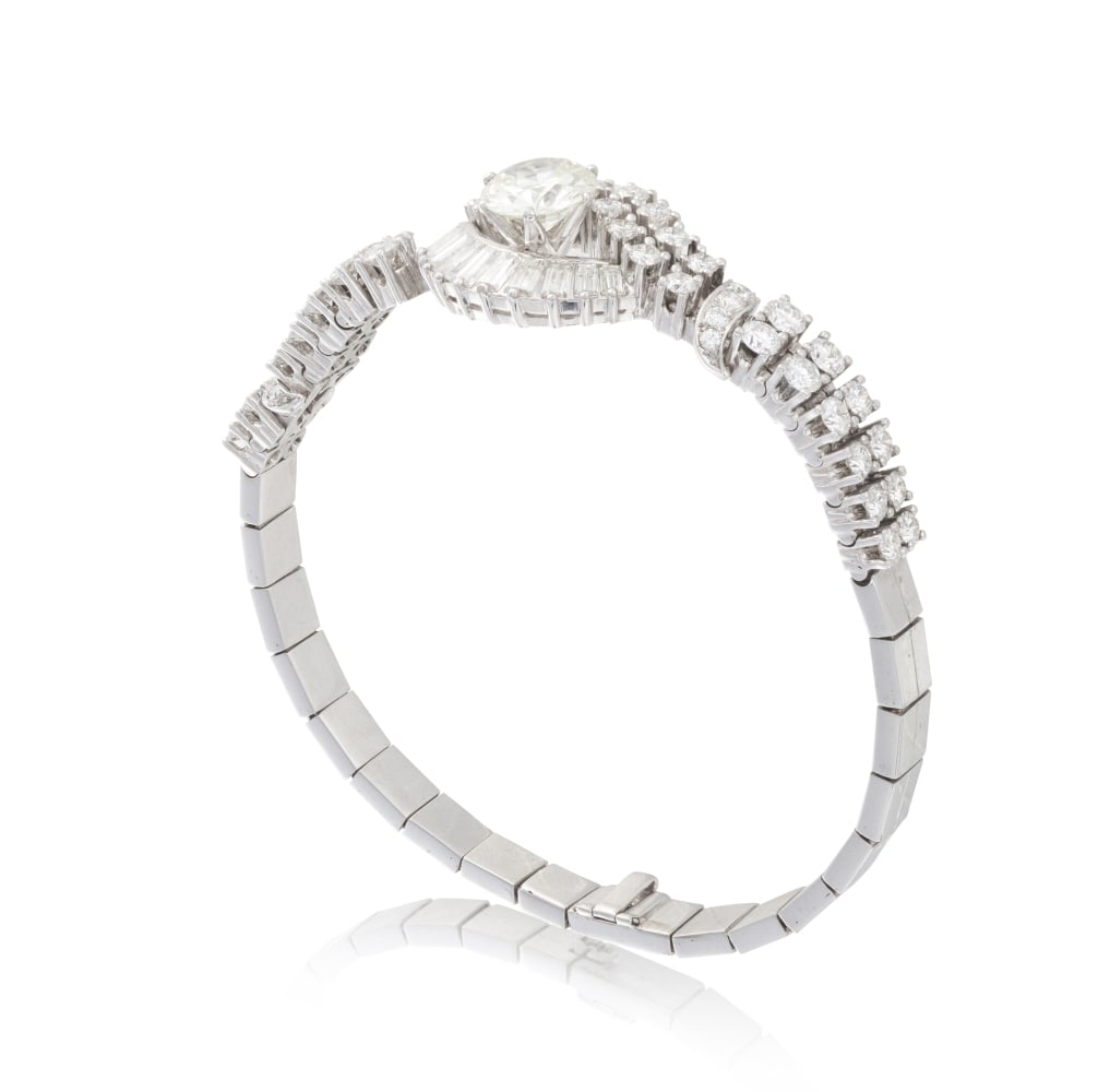 BRACELET DIAMANTS: BRACELET DIAMANTS Orné au centre d'un diamant de taille ancienne, surmonté de deux lignes diamants de taille brillant et de taille baguette, la monture en or gris terminant par des maillons