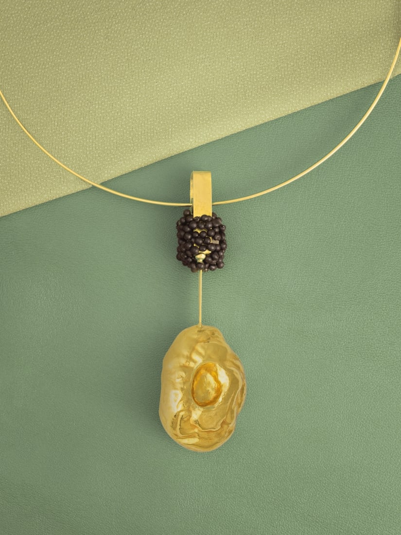 TAKIS: COLLIER 'MAGNÉTIQUE' EN OR ET FER, CIRCA 1980: TAKIS: COLLIER 'MAGNÉTIQUE' EN OR ET FER, CIRCA 1980 Le pendentif aimanté de perles de fer, retenant un motif oval abstrait, sur un collier torque en or jaune, avec son présentoir et so