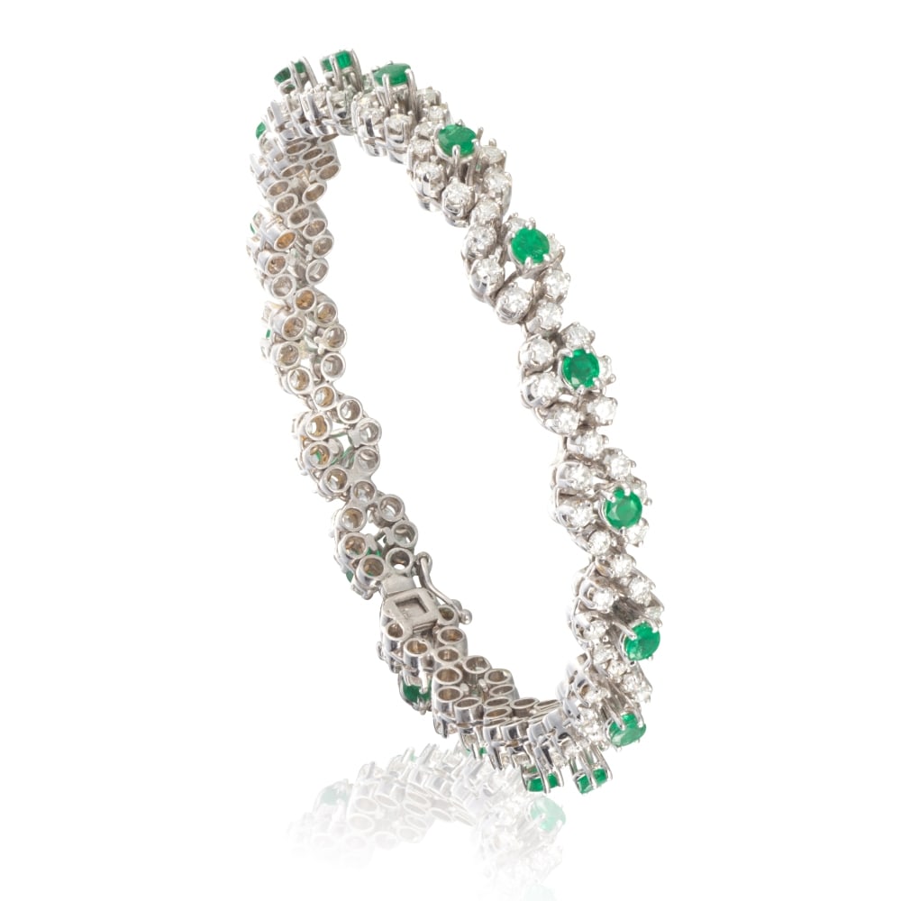 BRACELET ÉMERAUDES ET DIAMANTS: BRACELET ÉMERAUDES ET DIAMANTS Formant deux vagues entrelacées de diamants de taille brillant, accentué d'émeraudes de forme ronde, poinçon français d'import pour l'or 14