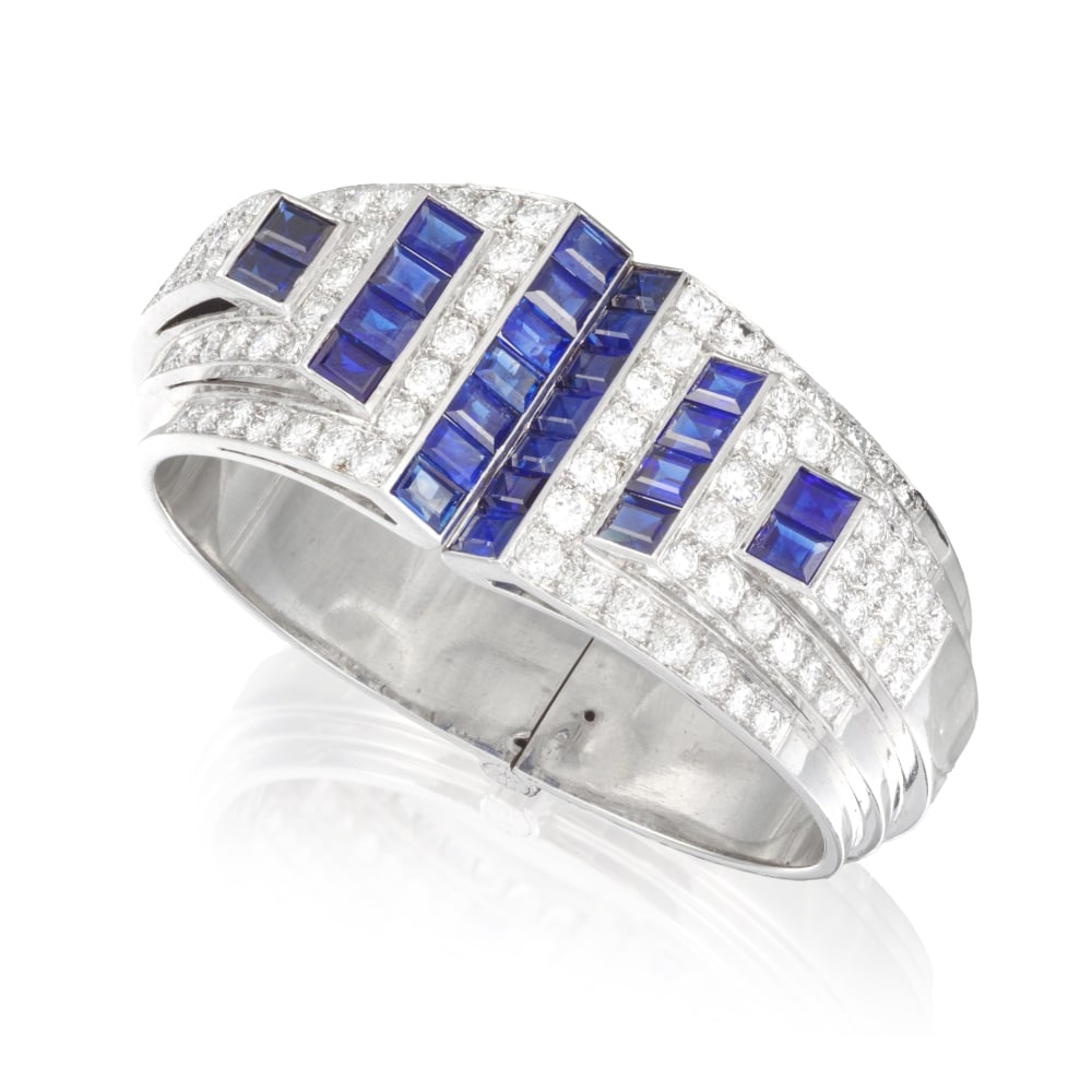 BRACELET MANCHETTE SAPHIRS ET DIAMANTS: BRACELET MANCHETTE SAPHIRS ET DIAMANTS Formant un jonc ouvrant, centré d'un motif géométrique serti de saphirs calibrés et de diamants de taille brillant, dispense accordée po