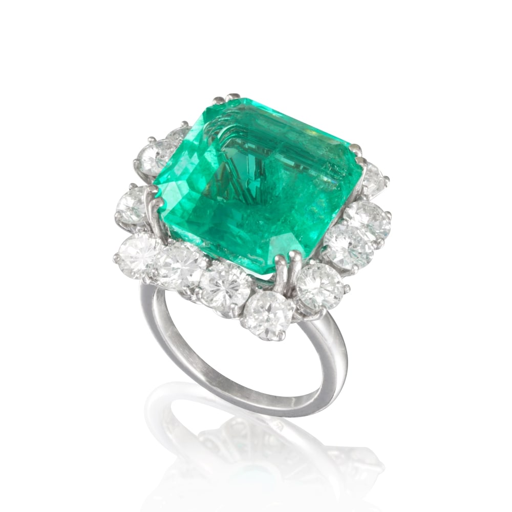 BAGUE ÉMERAUDE ET DIAMANTS: BAGUE ÉMERAUDE ET DIAMANTS L'émeraude de forme rectangulaire pesant 16.82 carats dans un entourage de diamants de taille brillant, poinçon français d'import pour l'or 18K (750 R