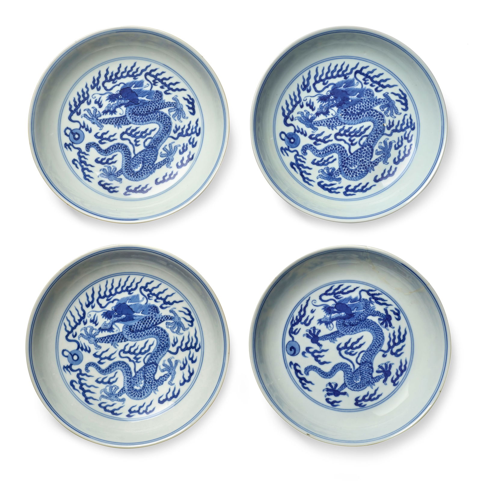 FOUR BLUE AND WHITE 'DRAGON' SAUCER DISHES Qianlong six-character seal marks and of the period (4): FOUR BLUE AND WHITE 'DRAGON' SAUCER DISHES Qianlong six-character seal marks and of the period Each boldly painted on the interior with a writhing five-clawed dragon chasing a flaming pearl amidst fla