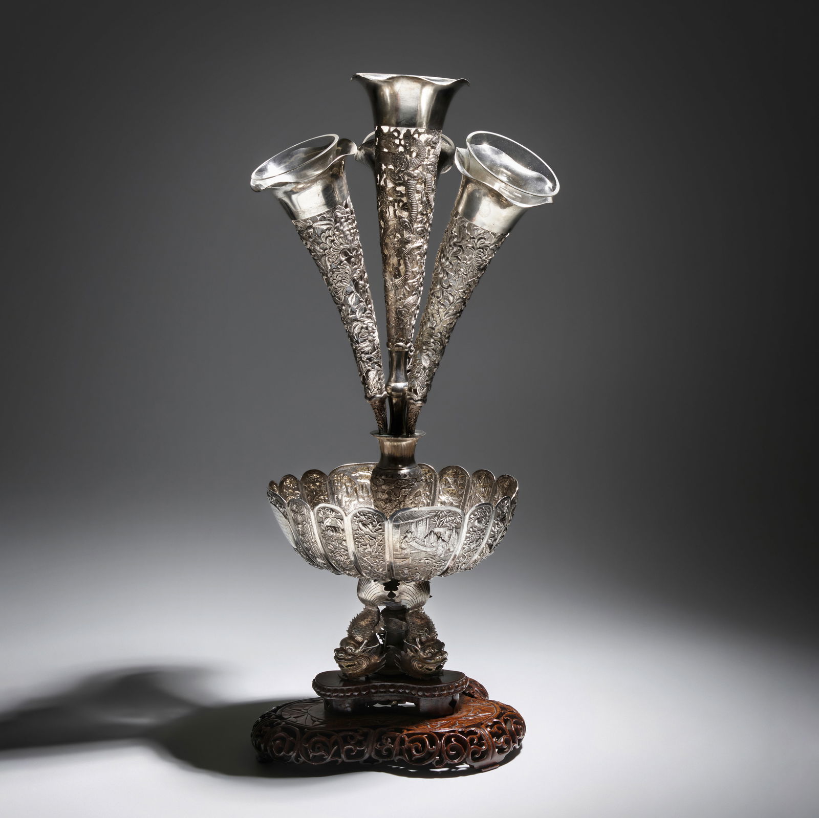 A RARE AND EXCEPTIONALLY LARGE SILVER ORNAMENTAL CENTERPIECE, EPERGNE Late Qing Dynasty: A RARE AND EXCEPTIONALLY LARGE SILVER ORNAMENTAL CENTERPIECE, EPERGNE Late Qing Dynasty Comprising a multi-petaled repousse bowl centered by a small baluster vase with tripod feet and chased with drag