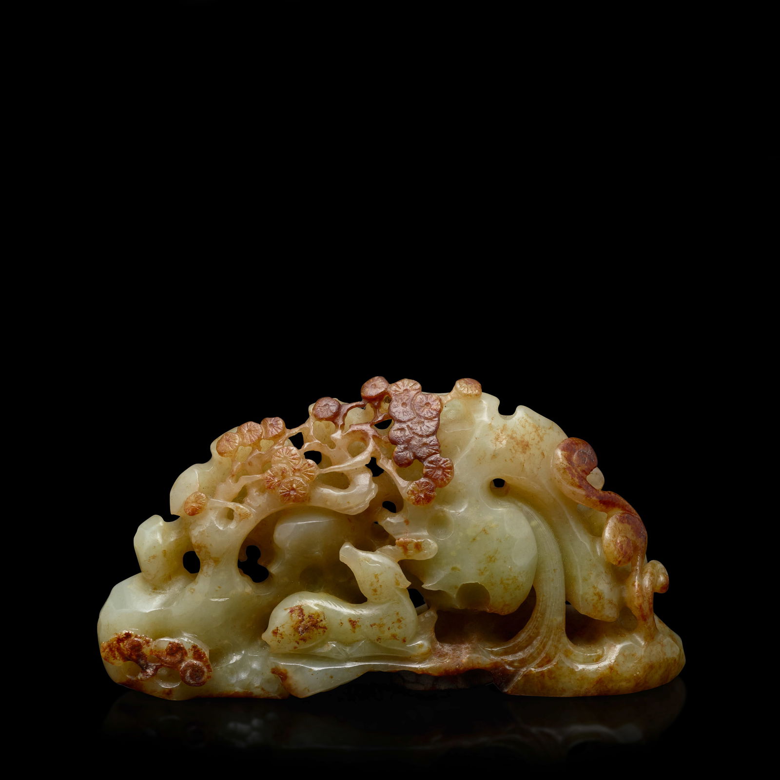 A RETICULATED JADE 'DEER AND CRANE' MINIATURE BOULDER Liao/Jin Dynasty (wood stand): A RETICULATED JADE 'DEER AND CRANE' MINIATURE BOULDER Liao/Jin Dynasty Of miniature boulder form, one side reticulated with a deer under a pine tree amidst swirling vegetations, the reserve side carve