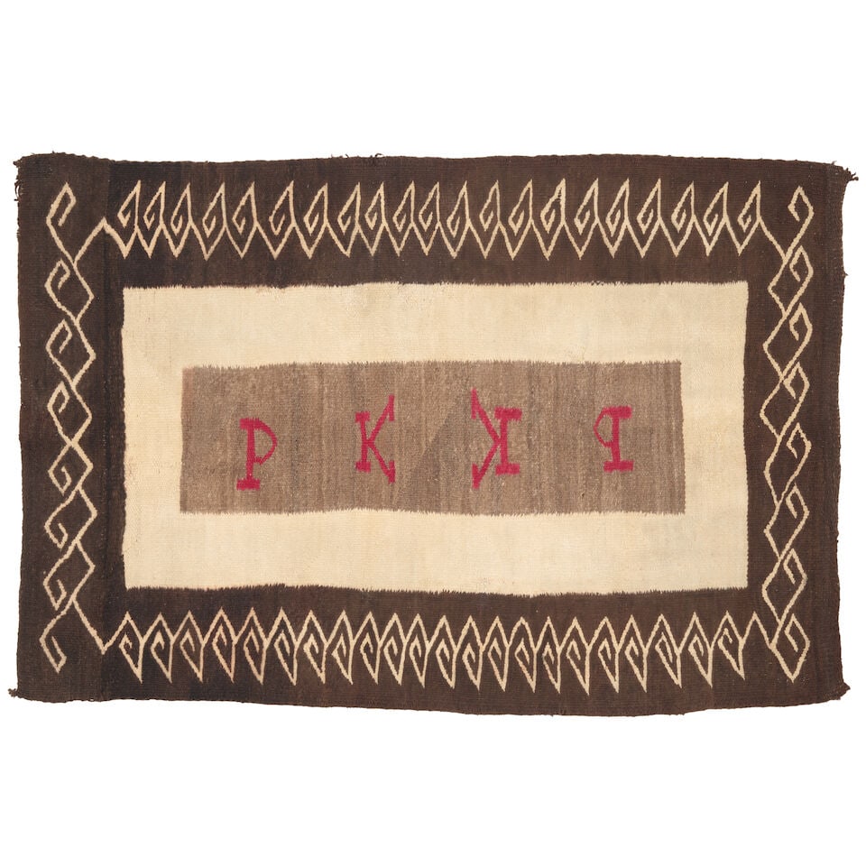A Diné (Navajo) double saddle blanket: A Diné (Navajo) double saddle blanket With a spiral border enclosing a pair of initials in red on grey-brown: PK. size approximately 4ft 3in x 2ft 10in For further information on this lot please