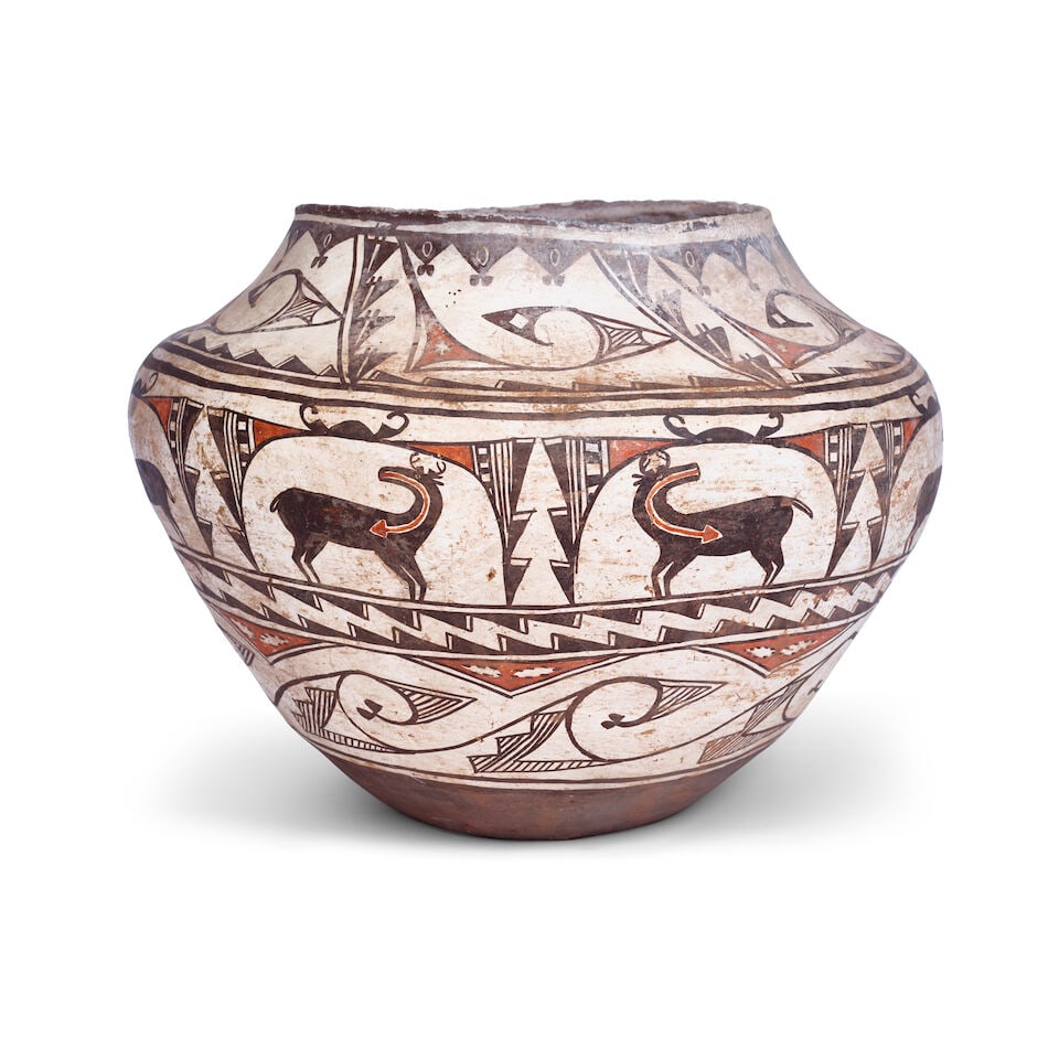 A Zuni polychrome olla: A Zuni polychrome olla A wide jar designed with multiple registers enclosing wave forms, heartline deer, and serrated bands, wear and losses to rim. height 10 1/4in, diameter 14in Footnotes: Provenanc