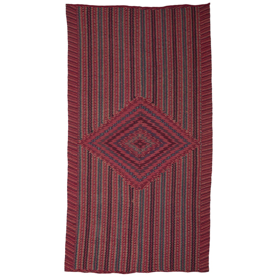 A Mexican Classic Saltillo serape: A Mexican Classic Saltillo serape Finely woven in two panels and joined down the center, centering a concentric serrated diamond medallion on a field of zigzag and serrated diamond banding, the