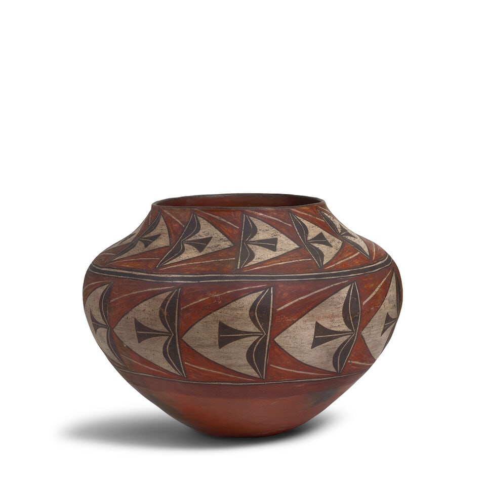 A Zia polychrome jar: A Zia polychrome jar Decorated with two bands of repeating oblique capped feather motifs. height 13 1/4in, diameter 17 3/4in For further information on this lot please visit Bonhams.com For further