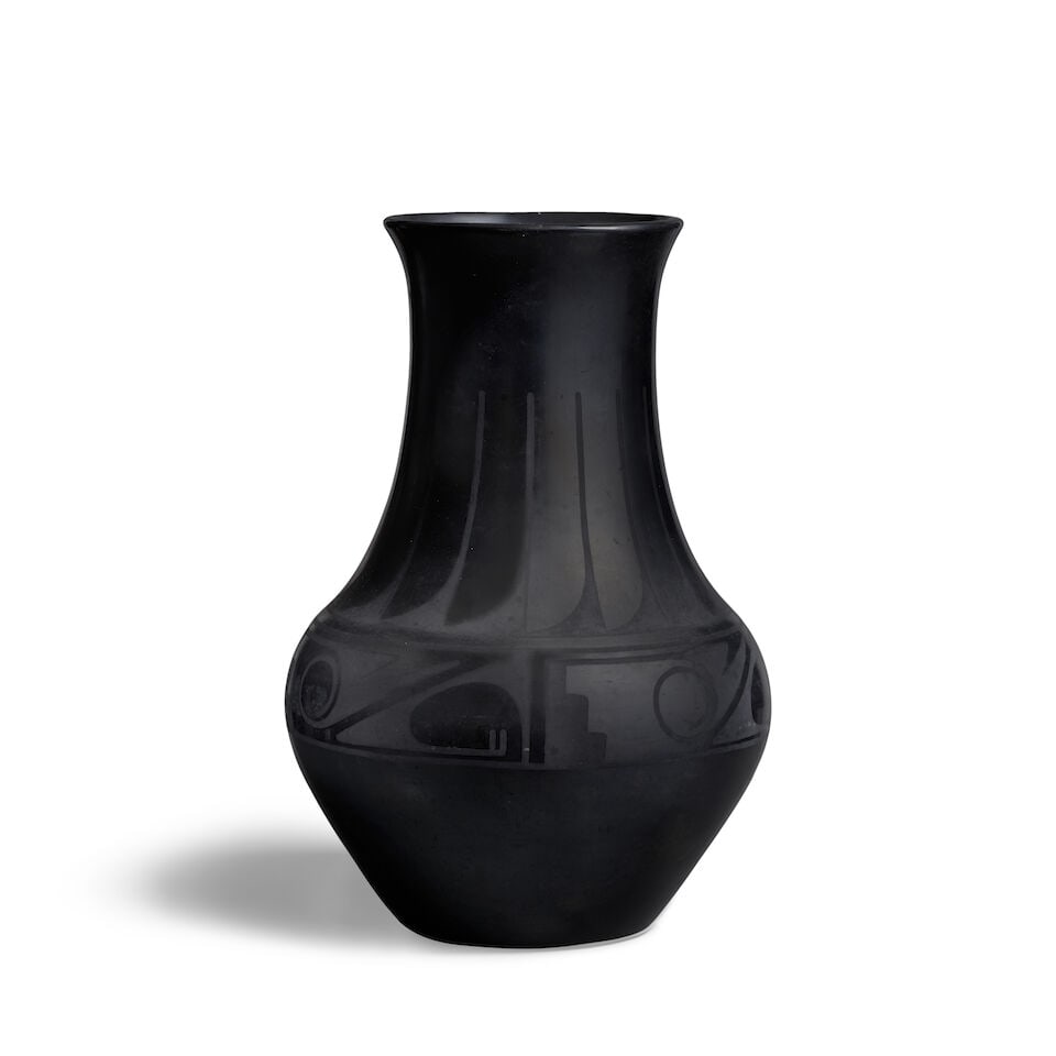 A Maria Martinez blackware pottery vase: Maria Martinez San Ildefonso Pueblo, (1887-1980), a blackware pottery vase, the neck worked with a feather motif band, four repeat registers below the shoulder, signed 'Marie' at the base. height 12