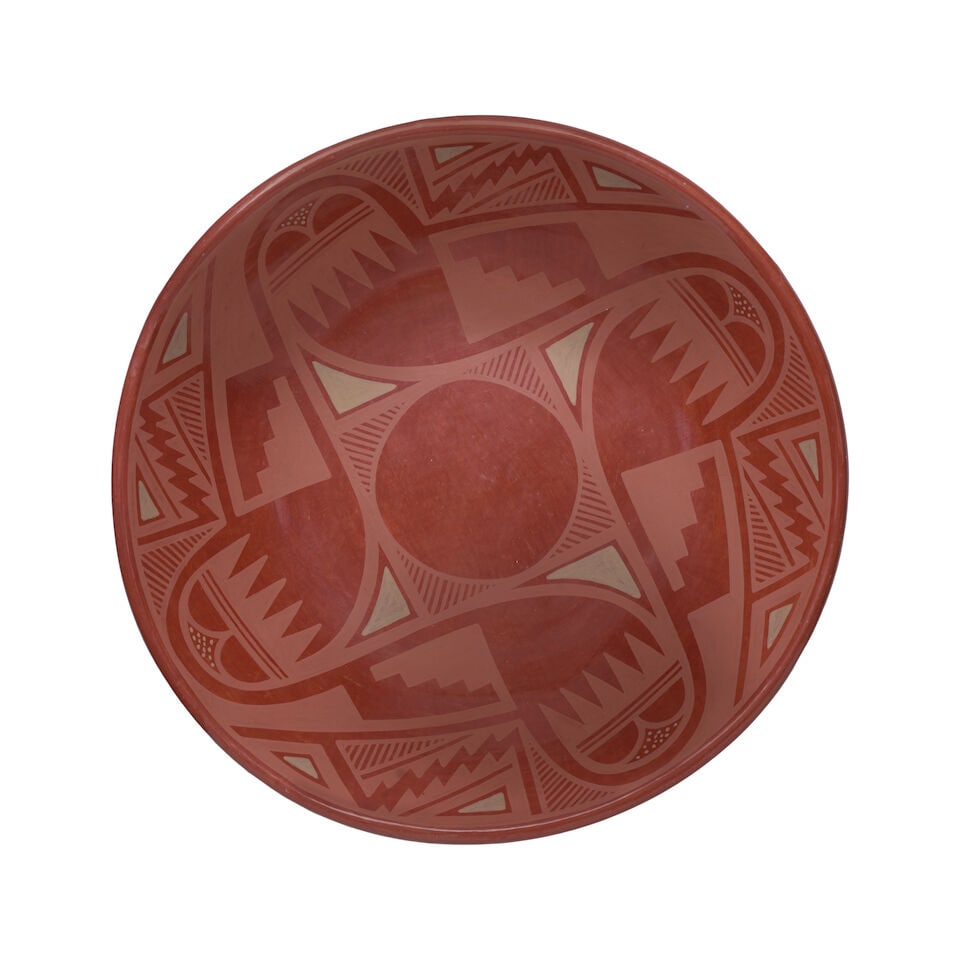 A Juanita Gonzales (Wo-Peen) redware pottery platter: Juanita Gonzales (Wo-Peen) Taos/San Ildefonso Pueblo, (1907-1990), a redware pottery platter, painted with a four-armed device flanked by geometric and serrated accents, signed 'Juanita' at the