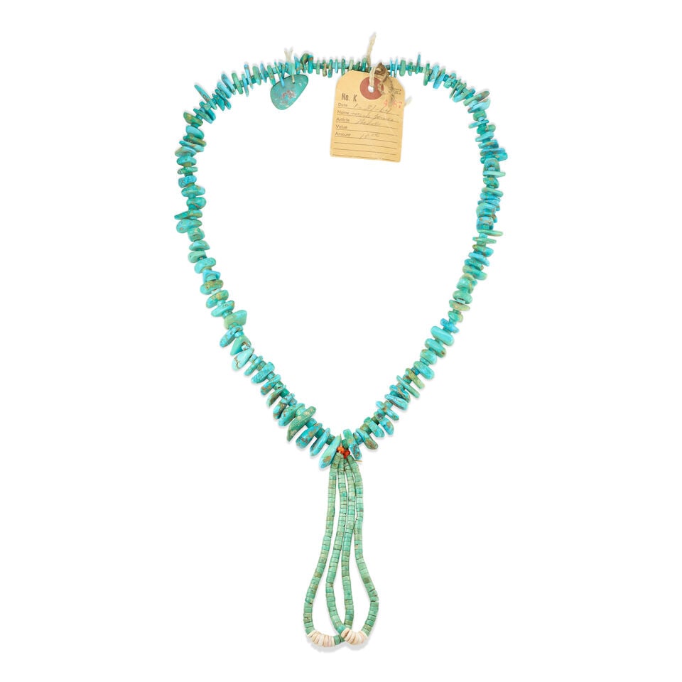 A Pueblo necklace: A Pueblo necklace Designed with a single strand of natural turquoise beads and graduated tabs, a larger applied tab near the closure, suspending a pair of turquoise jaclas. wearable length (not