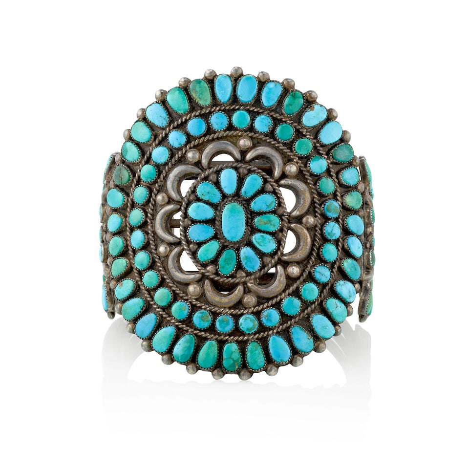 A large Zuni silver and turquoise cuff bracelet: A large Zuni silver and turquoise cuff bracelet Likely by a member of the Ondelacy family, of three wires surmounted by a large, pierced plaque set with rows of teardrop-shaped and rounded Blue Gem tu