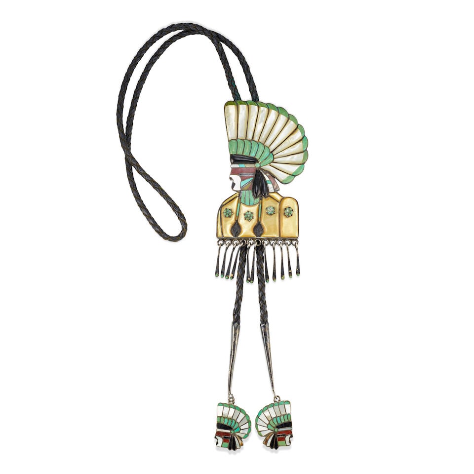 A Vera Luna pictorial multi-stone inlay bolo tie: Vera Luna Zuni, (1930-1982), a figural silver and multi-stone inlay bolo tie depicting a man in a feather bonnet in profile, with applied, turquoise-inlaid rosettes on the chest and turquoise-inlaid