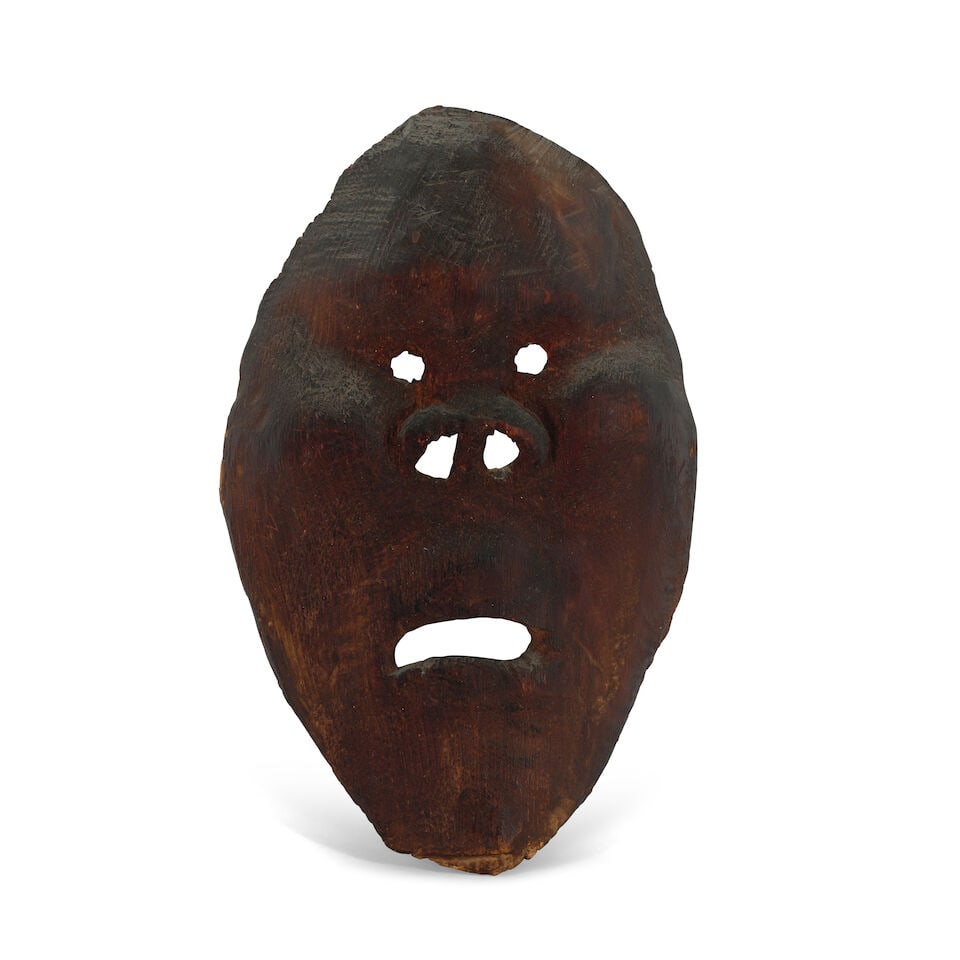 An Inupiaq mask: An Inupiaq mask Of carved cedar, with close-set eyes above a wide nose, the mouth slightly downturned. height 11 1/4in, width 6 3/4in Footnotes: Provenance Butterfields, San Francisco, CA, Native